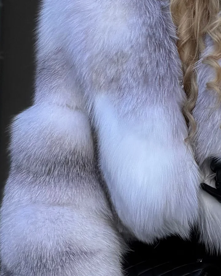 Белый натуральный мех с серыми полосами на рукаве шубы крупным планом